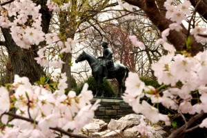 Statue of John Wesley surrounded by blossoms.