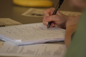 Image: Student writing in a spiral notebook